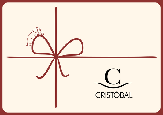 Illustration einer Geschenkkarte mit roter Schleife, kleinem Häschen und dem Logo von CRISTÓBAL – stilvolles Gutscheinmotiv für Interior-Geschenke und exklusive Einrichtungsideen.